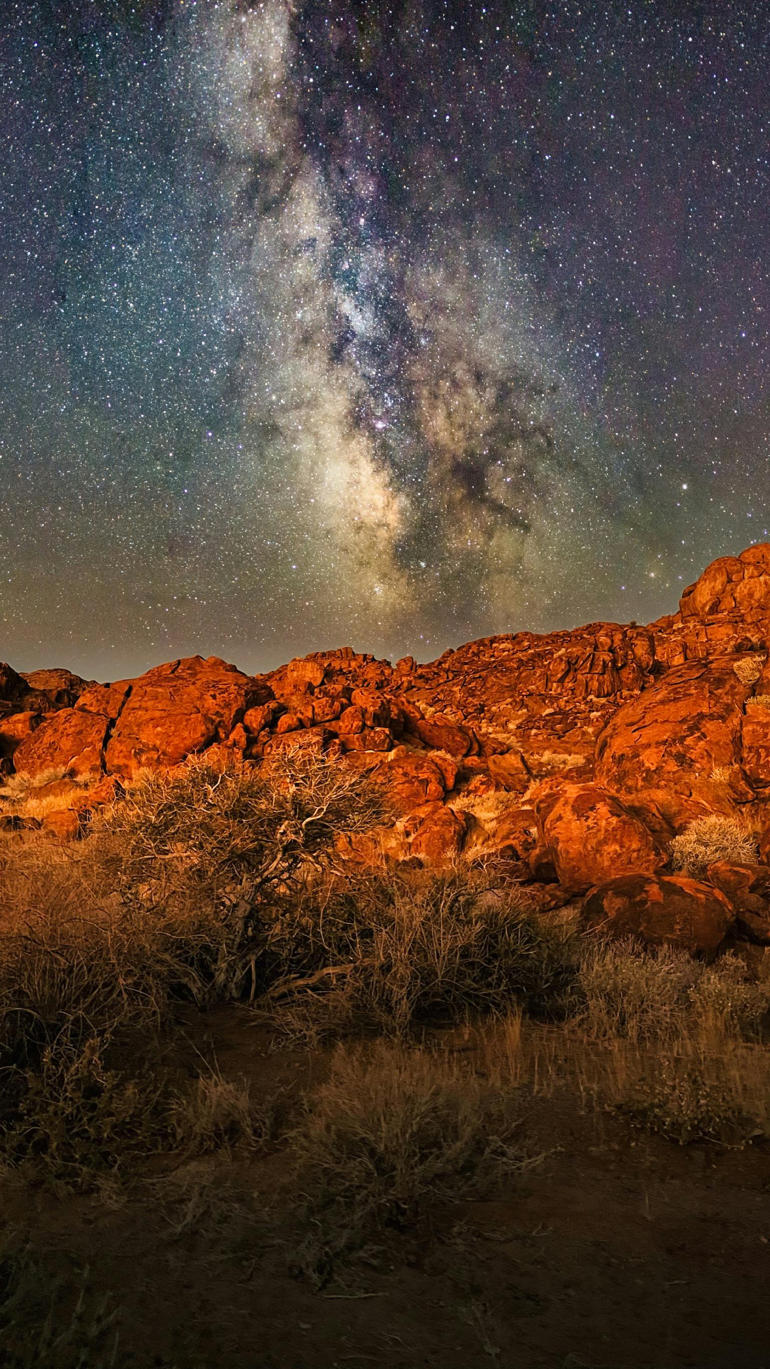 Night sky stars over red orange mountains desert